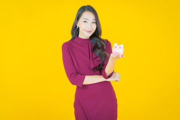 Portrait beautiful young asian woman with piggy bank