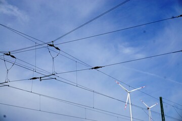 Himmel mit Windrädern und Zug-Elektrokabeln