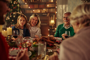 Joyful family celebrating Christmas at dining table.