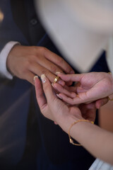 bride and groom holding hands change wedding ring