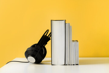 Headphones on book. Audiobook horizontal banner with copyspace. Online education and e-learning...