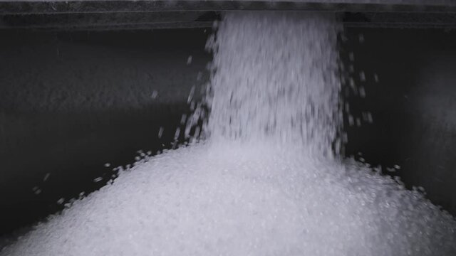 The plastic granules are poured into a large tank. Production of polymer compounds.