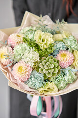 Beautiful bouquet of mixed flowers on women hand. the work of the florist at a flower shop. Delivery fresh cut flower. European floral shop.
