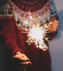 Burning Christmas fire in the hands of a modern woman close-up. Christmas atmosphere. new year