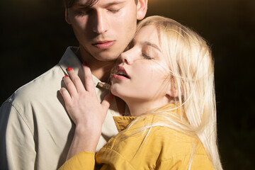 Fototapeta premium Young couple in love spends time together. Tenderness couple touch. Man embracing and going to kiss sensual woman.