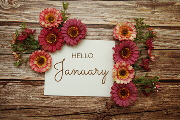 Hello January typography text with flowers on wooden background