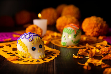 Sugar skulls with Candle, Cempasuchil flowers or Marigold and Papel Picado. Decoration...