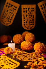 Candle with Cempasuchil orange flowers or Marigold. (Tagetes erecta) and Papel Picado. Decoration traditionally used in altars for the celebration of the day of the dead in Mexico