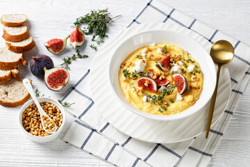 Pumpkin soup with feta, figs, pine nuts, top view