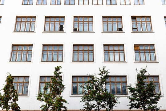 white facade with brown window frames of building on Rozhdestvenka street in Moscow city. The old office building 21/7 was built in 1930 by architect Kolli as house-commune Isotherma
