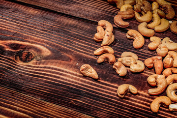 a handful of cashews are scattered on a wooden table. place for the inscription
