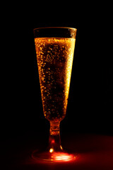 very cold beer with drops on disposable glass on black background