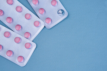 pink pills in packs vitamins pain reliever blue background