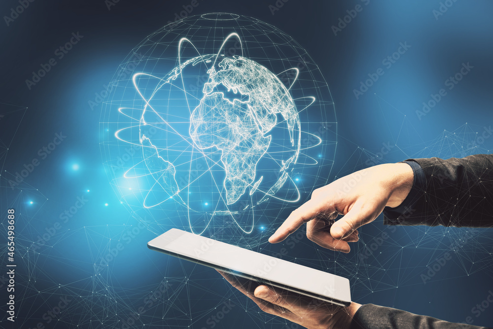 Poster Close up of businessman hand pointing at tablet with abstract glowing globe hologram on blurry blue background. Digital network, data and science concept.