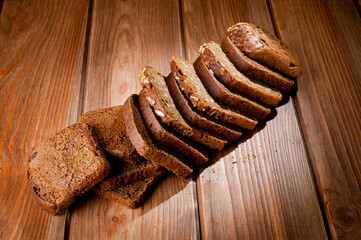 Bread made from natural products, on live sourdough, without baker's yeast, cut into skibbles on a wooden table surface.