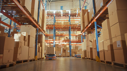 Future Technology: Automated Modern Retail Warehouse Delivery AGV Robots Transporting Cardboard...