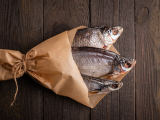 Dried  fish stockfish on a brown wooden table. Top view with space for text