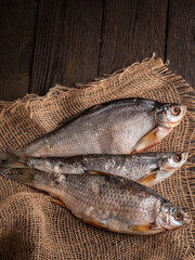 Dried  fish stockfish on a brown wooden table. Top view with space for text