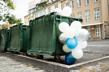 Fototapeta na wymiar Air balloons at garbage containers 