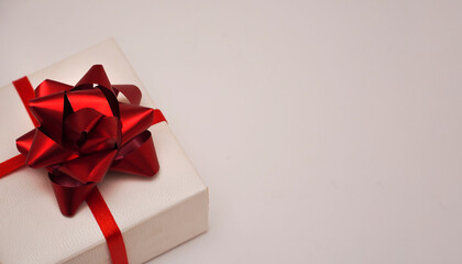   White gift textured box with red bow on white background. Christmas, New Year, Birthday, shopping sales concept. Banner.  Copy space.