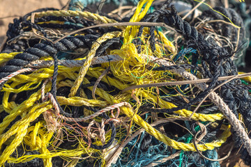 E Close multi colored black white yellow green old fishing twisted cotton ropes heap pile jumble...