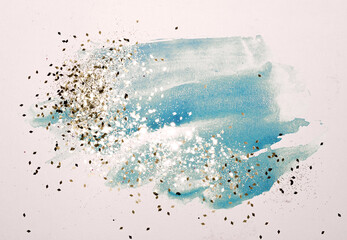 Fototapeta na wymiar Golden glitter on abstract blue watercolor splashes in vintage nostalgic colors