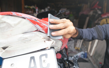 Preparation for painting a motorcycle. Hand in a sandpaper