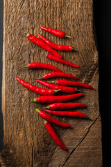 Hot raw  red chili on an old wooden board, spices.