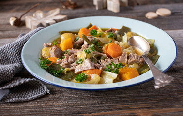 Plate with meat stew, potatoes, vegetables and cabbage