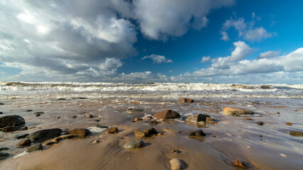 seascape with sea waves crashing on the shore and exploding, beautiful blue skies and white clouds over the sea, Vidzeme rocky seashore, Salacgriva rural area, Latvia