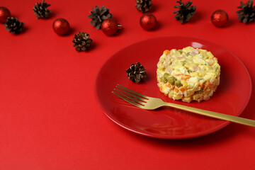Christmas concept of tasty food with Olivier salad on red background
