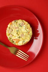 Christmas concept of tasty food with Olivier salad on red background