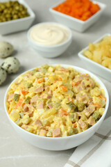 Olivier salad and ingredients on light background