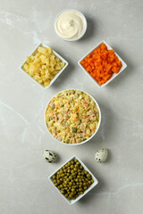 Olivier salad and ingredients on light background