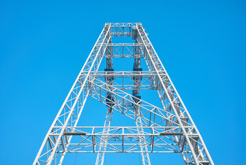 Close up picture of a gantry crane tower against the blue sky.