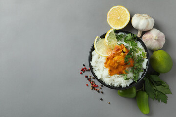 Chicken tikka with ingredients on gray background