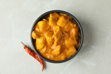 Chicken tikka with ingredients on light textured background