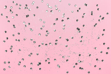 Pink background with silver sequins. Festive backdrop for your projects. Background for your product presentation. Christmas texture. Top view, copy space