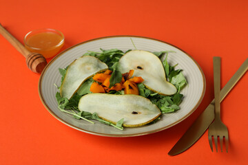 Concept of tasty eating with pumpkin salad on orange background