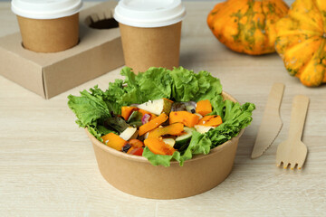 Concept of healthy food with pumpkin salad on wooden background