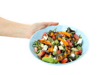 Woman's hand holding a plate of pumpkin salad, isolated on a white background
