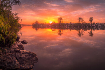 Obraz premium Beautiful Riverside Sunrise with Cloud Reflections