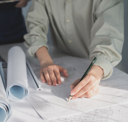 Architect working on blueprint. Architects workplace - architectural project, blueprints, ruler, calculator, laptop and divider compass. Construction concept. Blue print is fake only for stock photo.