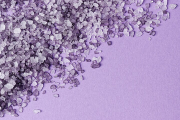 Top view of violet bath salt crystals background with copy space.