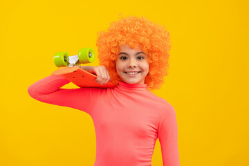 Happy girl child with orange hair in pink poloneck smile holding penny board, pennyboard