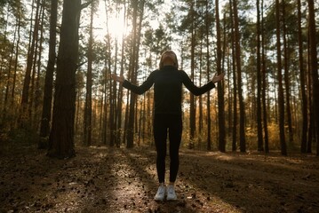 Fototapeta premium A young woman make yoga position at sunrise. in the autumn forest . High quality photo