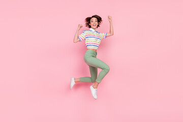 Fototapeta na wymiar Full body profile side photo of young girl happy positive smile rejoice success jump isolated over pink color background