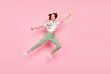 Fototapeta na wymiar Full body photo of young girl happy positive smile fly air superwoman catch parasol jump isolated over pink color background