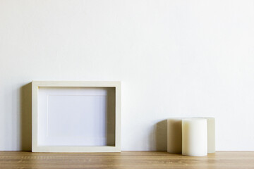 White frame with candles on table with nature light.