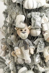Close up of gray-white Christmas tree with soft tigers, toys, and garlands
